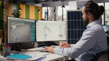 Ar-Ge araştırmacısı güneş yeşili enerji sistemlerini incelemek için belge dosyalarına bakıyor. Fotovoltaik karbon ayak izini geliştirmek için CAD yazılımı kullanan mühendis, kamera A