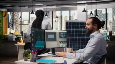 Ar-Ge uzmanı temiz enerji çözümleri geliştirir, kahve içer, iş arkadaşıyla konuşur. Mühendis iş arkadaşıyla sohbet ediyor, içecekten keyif alıyor, yenilenebilir enerji üretimini PC, kamera A 'da optimize ediyor.