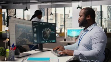 Ofisteki mühendis rüzgar türbini CAD tasarımı üzerinde çalışıyor, sürdürülebilir enerji araştırması yapıyor. Ar-Ge uzmanı yazılım, kamera A kullanarak rüzgar enerjisi üreteci altyapısının dijital modellemesini yapıyor.