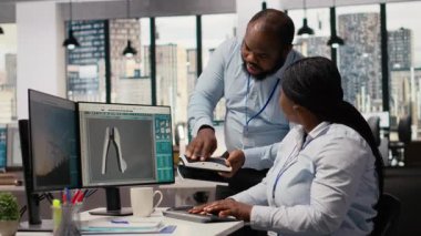 Ar-Ge işyerinde güneş enerjili cihaz tasarlayan teknisyenler yeşil enerji teknolojisi üzerinde çalışıyorlar. Ofisteki ekip çalışanları güneş cihazları prototipleri, kamera B oluşturuyorlar.