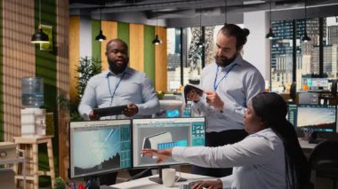 Ofisteki mühendisler yenilikçi güneş enerjili cihaz için beyin fırtınası yapıyorlar. Ekip çalışması Ar-Ge uzmanları taşınabilir güneş paneli aygıtlarını deniyorlar, verimliliği arttırmak için birlikte çalışıyorlar, kamera A