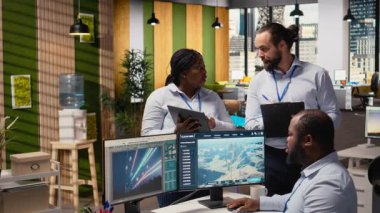 Mühendislik ekibi temiz enerji üretimi için tasarlanmış fütüristik rüzgar türbini kavramına beyin fırtınası yapıyor. Ofis araştırmalarında çalışan takım arkadaşları VAWT yenilikleri, kamera A