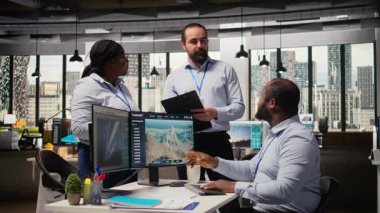 Ofisteki mühendisler yeşil enerji üretim teknolojisi testi yapıyorlar. Takım çalışma arkadaşları yenilenebilir enerji sektöründe biyolojik çeşitliliğin korunması için en son çözümleri araştırıyorlar, kamera A