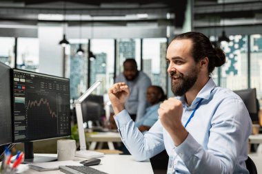 Başarılı bir piyasa tahmini yapıp kar elde ettikten sonra kutlama yapan bir memur. Komisyoncu şirket çalışanı, portföy değeri artışları sonrasında başarı elde ederek yüksek kârlar elde ediyor.