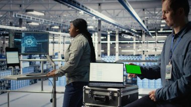 Veri merkezi çalışanı, derin öğrenme yazılımları uygularken izole ekran akıllı telefonu kullanır. Sunucu merkezi çalışanı, Yapay Zeka sistemlerini veri tabanlarıyla, kamera A ile eğitirken krom anahtar cep telefonu kullanır