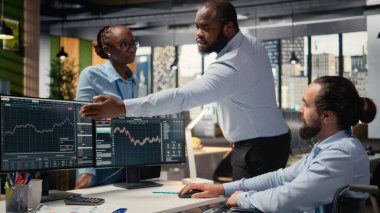 Tekerlekli sandalyedeki portföy yöneticisi ve iş arkadaşları yatırım gelirlerini artırmak için borsayı analiz ediyorlar. Engelli ve görevdeki meslektaşları yatırım olanaklarını tanımlıyor