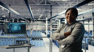 Sunucu çiftliğinde gülümseyen bilişim uzmanının portresi makine öğrenme sistemlerini optimize ederek görevleri yerine getiriyor. Mutlu veri merkezi kadın mühendisi sinirsel ağları ayarlıyor AI model parametreleri, kamera A