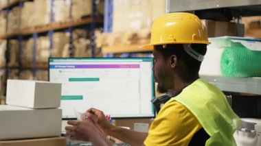 İşçi etiketleri uyguluyor ve barkod etiketlerindeki takip bilgi numaralarını tarıyor, karton kutulara nakliye etiketleri kaydediyor. Tamamlama Merkezi personeli paket durumu ve teslimat güzergahı gösteriyor. Kamera B.