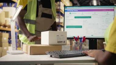 Kutuların sevkiyat detayları için barkodları tarayan Afrikalı Amerikalı bir kadın, paket izleme yazılımının hava yolu faturası verilerini doğru paket güncellemeleri ile kaydediyor. Tarayıcı teknisyeni. Kamera A.