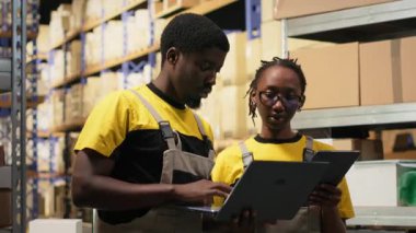 Depo çalışanları paketleri denetliyor. Cihazlar hakkında bilgi topluyor, sevkiyat için kargo hazırlıyor. Depodaki dağıtım işlemlerini envanter işleme araçlarıyla yürüten insanlar. Kamera B.