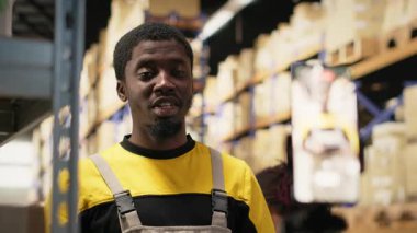 Depoda canlı yayında işbirliği yapan iş arkadaşları parsel işleme ve işleme sergiliyorlar. Afrikalı Amerikalı işçiler ticari bir kampanya için ürünler sunuyorlar. Kamera B.