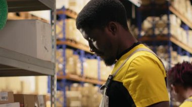 Çalışan, dolum merkezindeki karton kutularda barkod tarayıcısı kullanıyor. Organize raf, paket etiketleri ve güzergah planlama destek dağıtımı ve sevkiyatı. Lojistik merkezi. Kamera B.