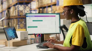 Kara Depo çalışanı, teslimat ve sipariş işlemlerine yardımcı olması için yapay zeka sanal asistanıyla envanter lojistiği yönetiyor. Çevrimiçi alışveriş perakende faaliyeti. Kamera B.