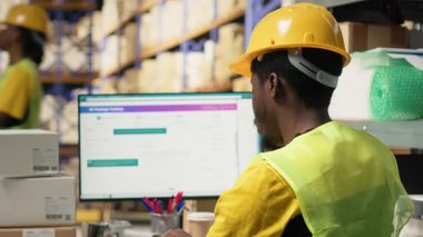 Depo çalışanı, havayolu fatura etiketlerinin izlenmesi ve e-ticaret perakende sektörü için ithalat ihracat operasyonlarının güvence altına alınması ile sipariş kaydı yapıyor. Adam sıra gereğince çalışır. Kamera B.