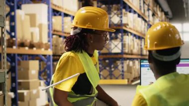 Siyahi çalışanlar depo ortamında mutlu bir beşlik jesti paylaşıyorlar, paket sevkiyatı takım çalışması başarısından gurur ve memnuniyet duyuyorlar. Verimliliği sağlamak için görevleri zamanında bitiriyorum. Kamera B.