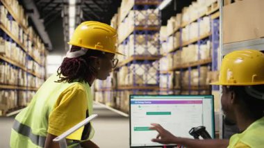 Siyahi çalışanlar depo ortamında mutlu bir beşlik jesti paylaşıyorlar, paket sevkiyatı takım çalışması başarısından gurur ve memnuniyet duyuyorlar. Verimliliği sağlamak için görevleri zamanında bitiriyorum. Kamera A.