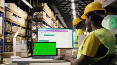 Doldurma merkezi erkek personeli yeşil ekran ile parsel durumunu onaylıyor, çevrimiçi alışveriş büyük iş deposunda sipariş işlemlerini yönetiyor. Perakende ihracat işlemleri. Kamera A.