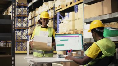 Genç adam barkodlarda tarayıcı kullanıyor ve dağıtım merkezine etiket takıyor. Organize raflar, paket etiketleri ve güzergah planlaması verimli sevkiyat ve sipariş yerine getirilmesi. Kamera A.