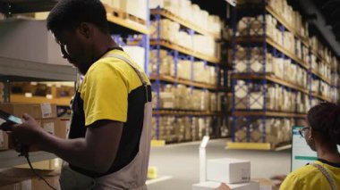 Çalışan, dolum merkezindeki karton kutularda barkod tarayıcısı kullanıyor. Organize raf, paket etiketleri ve güzergah planlama destek dağıtımı ve sevkiyatı. Lojistik merkezi. Kamera A.