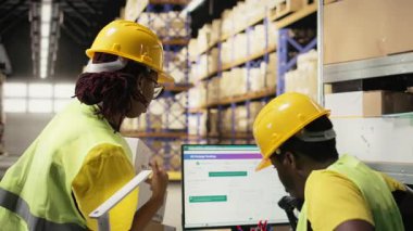 Afrikalı Amerikalı işçiler, PC 'deki bir paket izleme yazılımının, ithalat işlemleri için endüstriyel depoda çalışmasını sağlıyorlar. Envanter ve sevkiyat protokolünü yönetiyorum. Kamera A.