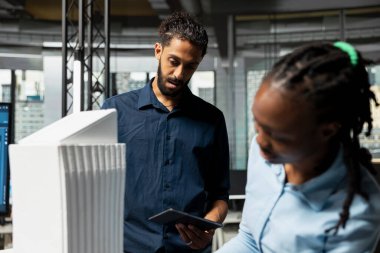 Üç boyutlu modelleri gözden geçiren çok ırklı geliştiriciler, inşaat için bir düzen, emlak geliştirme için şehir planlama oturumu oluşturmak için ayrıntıları inceliyorlar. Yeni bir akıllı şehir mahallesinin planları..