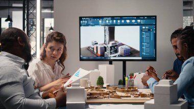 Mühendisler ve gayrimenkul müteahhitleri, mimari 3D modeller, modern altyapı için beyin fırtınası fikirleri, inovasyon ve konut planlarını gözden geçiriyorlar..