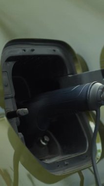 Yükleme rıhtımına bağlı sıfır emisyon EV aracının dikey videosu daha temiz bir çevreye olan bağlılığı vurguluyor. Elektrikli araba güç kaynağına takıldı, küresel itişin bir parçası olarak