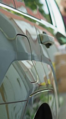 Sürücünün EV 'yi şarj etmek için EVSE istasyonunda durdurduğu dikey video, sıfır emisyon teknolojisi kavramı. Elektrikli aracı park eden adam, alternatif enerji gösterisi.