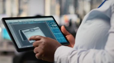Alternatif enerji teknolojisiyle güneş enerjili cihaz tasarımı yapmak için tablet kullanan teknisyenleri kapatın. Ar-Ge çalışanı dokunmatik ekran aygıtı kullanır, eko solar cihaz prototipi, kamera B