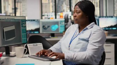 Gülümseyen mühendisin portresi temiz enerji teknolojisiyle güneş enerjili cihaz tasarımı yapmak için PC kullanıyor. Ar-Ge ofisindeki mutlu Afrikalı Amerikalı kadın ekolojik güneş aygıtı prototipi, kamera B 'yi yaratıyor.