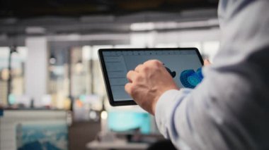 Rüzgâr türbini sürdürülebilir yapmak ve karbon ayak izini azaltmak için CAD uygulamasını tablet üzerinde kullanarak mühendisi kapat. Dokunmatik ekran cihazını araklayan Ar-Ge uzmanı, çevre dostu yel değirmeni parçalarına bakıyor, kamera A