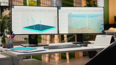 Araştırma ve geliştirme ofisindeki bilgisayar ekranlarında rüzgar türbini simülasyonu. Yenilenebilir enerji mühendisliğini ve sürdürülebilir teknoloji yeniliğini destekleyen bilgisayar monitörleri üzerindeki CAD yazılımı