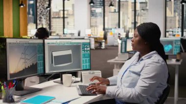 Gülümseyen mühendisin portresi temiz enerji teknolojisiyle güneş enerjili cihaz tasarımı yapmak için PC kullanıyor. Ar-Ge ofisindeki mutlu Afrikalı Amerikalı kadın ekolojik güneş cihazı prototipi, kamera A 'yı yaratıyor.