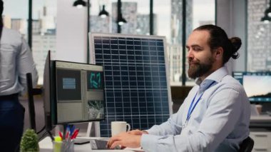 Ar-Ge uzmanı temiz enerji çözümleri geliştirir, kahve içer, iş arkadaşıyla konuşur. Mühendis iş arkadaşıyla sohbet ediyor, içecekten keyif alıyor, yenilenebilir enerji üretimini PC, kamera B 'de optimize ediyor.