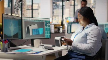 Ofisteki mühendis gelişmiş güneş pili teknolojisini değerlendiriyor temiz enerji tabanlı cihaz. Ar-Ge uzmanı güneş paneli lambası prototipini test etmek için ışıkları açar, güç çıkışını kontrol eder, kamera B