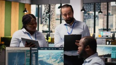 Mühendislik ekibi temiz enerji üretimi için tasarlanmış fütüristik rüzgar türbini kavramına beyin fırtınası yapıyor. Ofis araştırmalarında çalışan takım arkadaşları VAWT 'nin yenilikleri, kamera B