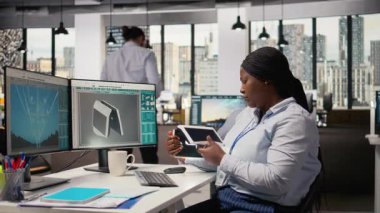 Ofisteki mühendis, yenilikçi güneş enerjili cihazı test ediyor, ışıkları açıyor. Çevre koruma verimliliğini arttırmak için taşınabilir güneş paneli aygıtı denemesi yapan Ar-Ge uzmanı, kamera A