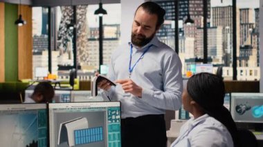 Ofisteki mühendisler yenilikçi güneş enerjili cihaz için beyin fırtınası yapıyorlar. Ekip çalışması Ar-Ge uzmanları taşınabilir güneş paneli aygıtlarını deniyorlar, verimliliği arttırmak için birlikte çalışıyorlar, kamera B