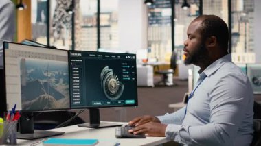 Rüzgâr türbininin aerodinamiğini optimize etmek için CAD yazılımı kullanan teknisyen karbon ayak izini azaltıyor. Afrika kökenli Amerikalı adam, çevre dostu yel değirmeninin gelişmiş materyallerini test ediyor.