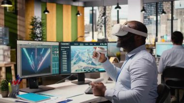 İşçi, elektrik şebekesi ve rüzgar çiftliği düzenini optimize etmek için VR kulaklık kullanıyor ve temiz enerji sistemlerini geliştiriyor. Teknisyen elektrik hatları ve fütüristik rüzgar türbini ve kamera A 'nın sanal gerçeklik simülasyonunu yapıyor.