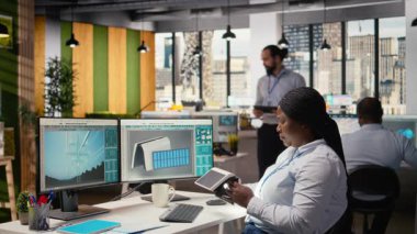 Ofisteki mühendis gelişmiş güneş pili teknolojisini değerlendiriyor temiz enerji tabanlı cihaz. Ar-Ge uzmanı güneş paneli lambası prototipini test etmek için ışıkları açar, güç çıkışını kontrol eder, kamera A