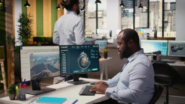 Rüzgâr türbininin aerodinamiğini optimize etmek için CAD yazılımı kullanan teknisyen karbon ayak izini azaltıyor. Afrika kökenli Amerikalı adam, çevre dostu yel değirmeninin gelişmiş materyallerini test ediyor. Kamera A