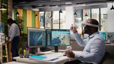 Mühendis temiz enerji üretim teknolojisi testi için sanal gerçeklik simülasyonu kullanıyor. VR kulaklık takan adam yenilenebilir enerji sektöründeki son teknoloji çözümler için Ar-Ge yapıyor. Kamera A.