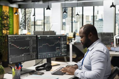 Piyasa dalgalanmalarından yararlanmak için ofisteki borsa simsarı çabucak hisse alıp satıyor. Borsa fiyat hareketlerini hızlı kar fırsatları için analiz eden bir şirket çalışanı.