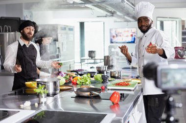 Çeşitli şefler kamerada gurme pişirme gösterisi çekiyorlar, izleyicilere kompleks tariflerde ustalaşmayı öğretiyorlar. Profesyonel yemek teknikleri üzerine çevrimiçi kurs için mükemmel bir mutfak düzeni..
