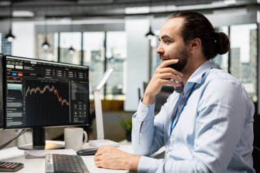 Risk analisti borsa dalgalanma işaretlerini gözden geçirmek için ticaret platformunu kullanıyor. Prop firması çalışanı portföy performans raporlarını analiz ediyor, potansiyel mali riskleri kontrol ediyor