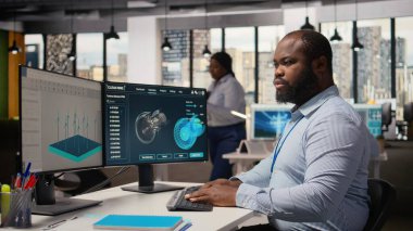 Ofisteki yenilenebilir enerji mühendisi yel değirmeni tarım altyapısını çevre dostu türbinlerle güncelliyor. Ar-Ge çalışanı rüzgar enerjisi üretimi ekipmanları için sürdürülebilir materyalleri araştırıyor. Kamera A