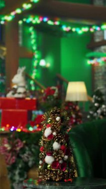 Noel ağacı, ışıklar ve kış tatili boyunca diğer süslemelerle süslenmiş dikey video odası. Noel Baba atölyesi Noel çoraplarıyla süslenir, bayram geleneğini yayar.