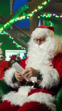 Evde Noel Baba gibi giyinmiş dikey videocu çocuk hediye isteyen çocuklardan gelen mektubu açıyor. Kırmızı Noel Baba kostümü giyen son sınıf öğrencisi içinde dilek listesi olan parşömenleri açıyor.