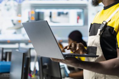 Mühendis modern fabrikada enerji optimizasyon yazılımı üzerinde çalışan PC 'deki güneş paneli sistemlerini ayarlıyor. Uzman, yüksek teknolojili otomatikleştirilmiş bir tesiste fotovoltaik operasyonları yönetiyor. Kamera A.